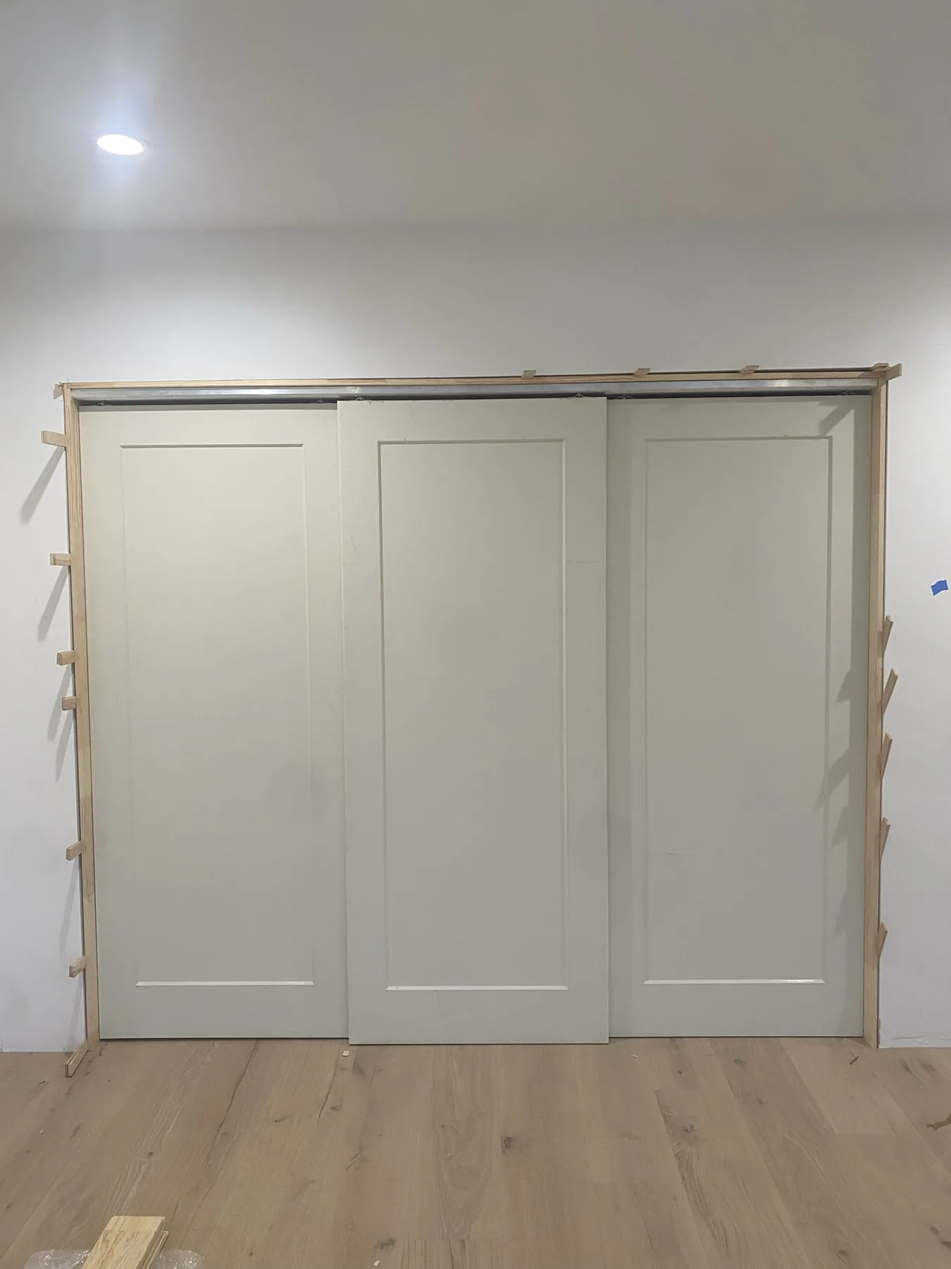 Unpainted triple bypass door slabs hung at E Calle Ventura