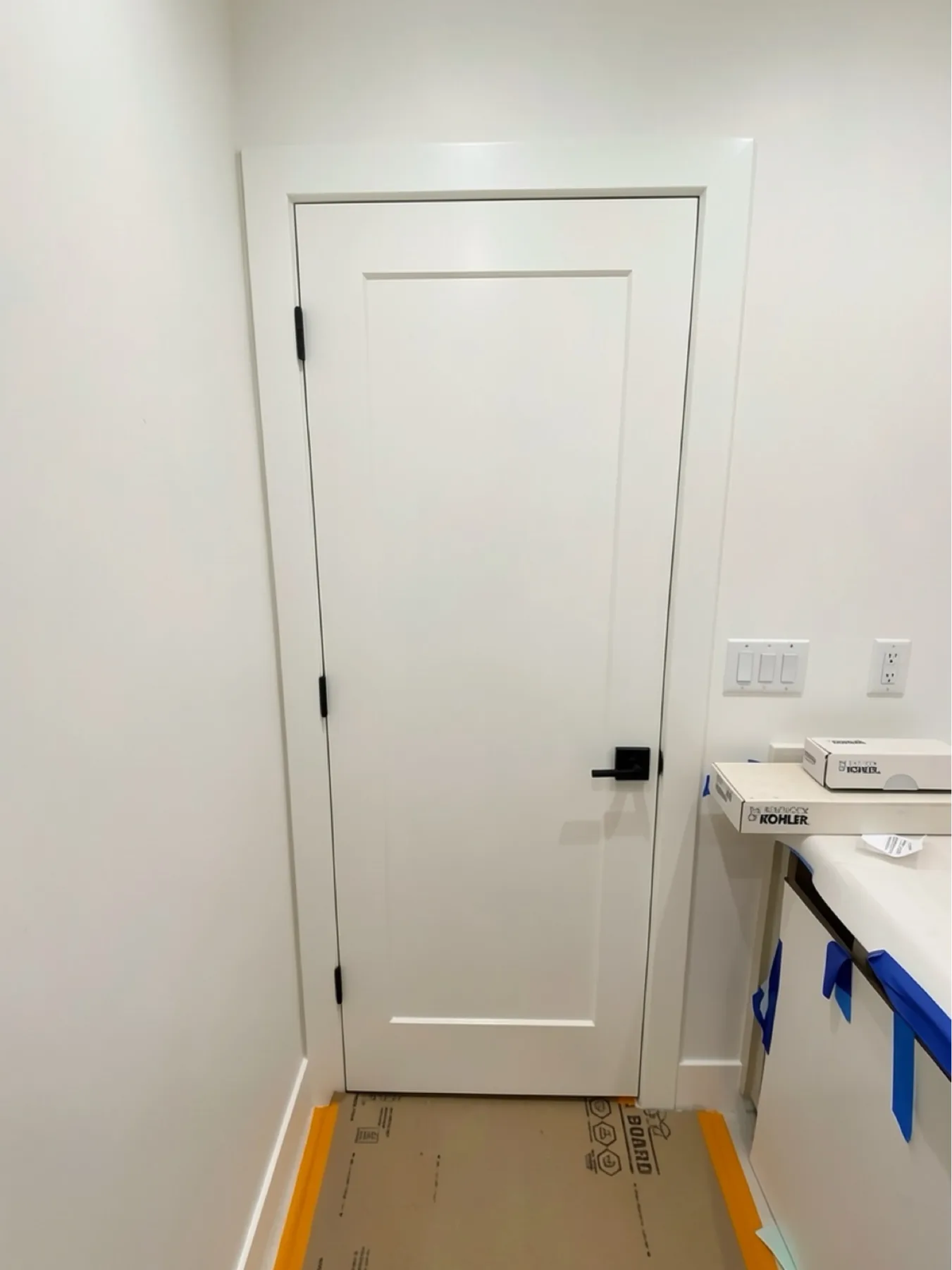 Finished bathroom door installation with protected work area at E Calle Ventura