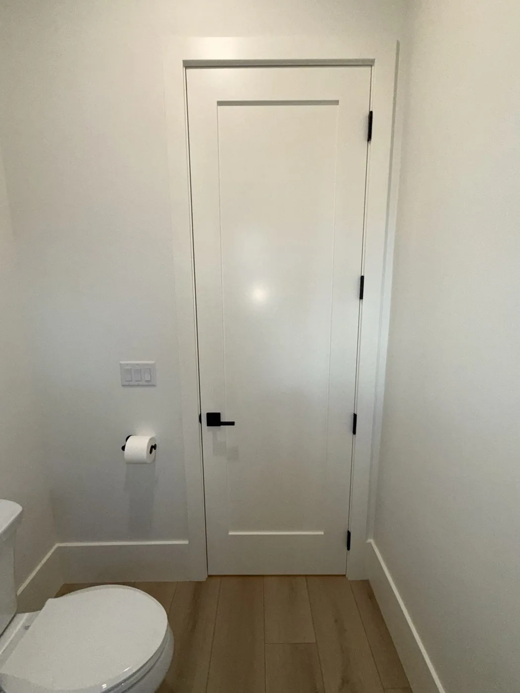 Solid-core interior door with casing, hardware, and baseboard at The El Sendero Project