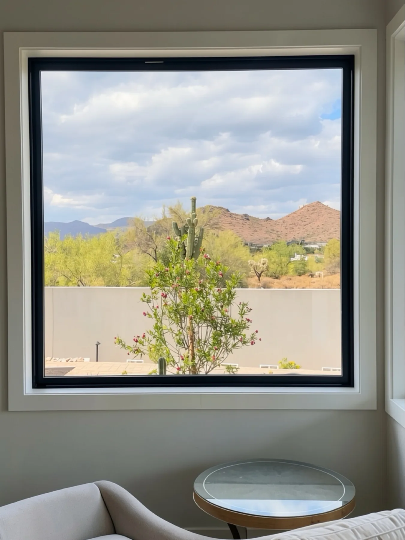 Window jamb and trim installation with chair and desert view at The El Sendero Project