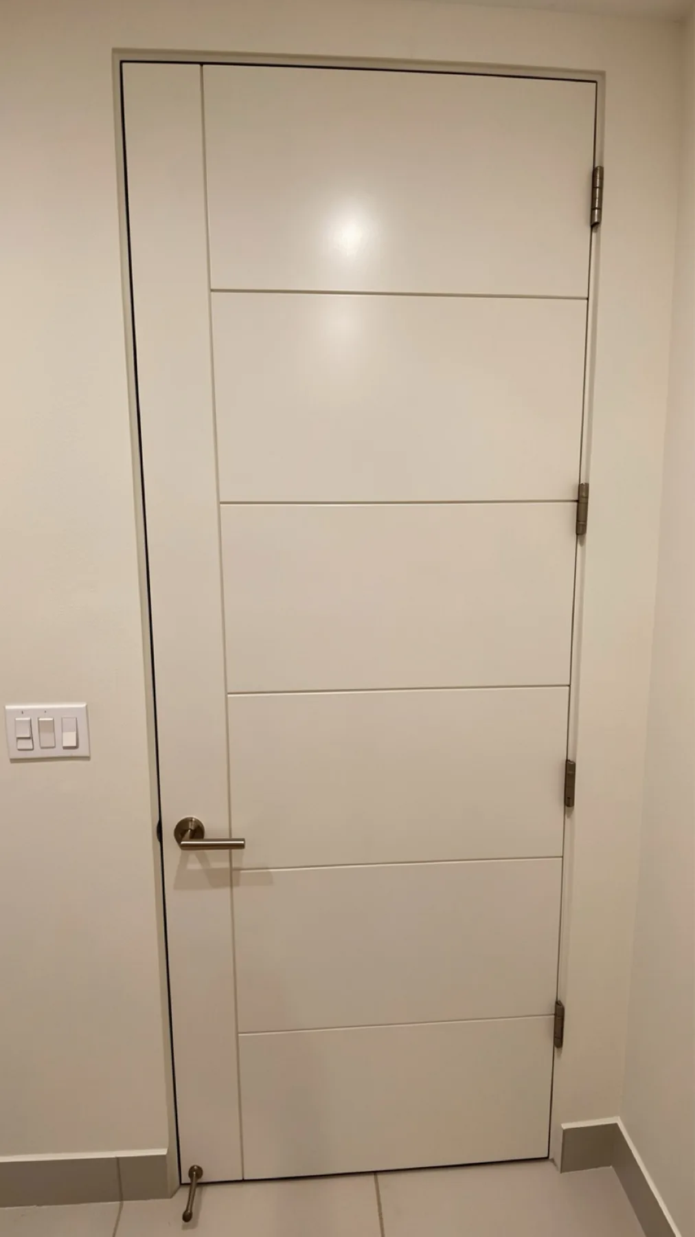 Finished bathroom door installation with horizontal panel detail at The Phoenician Project