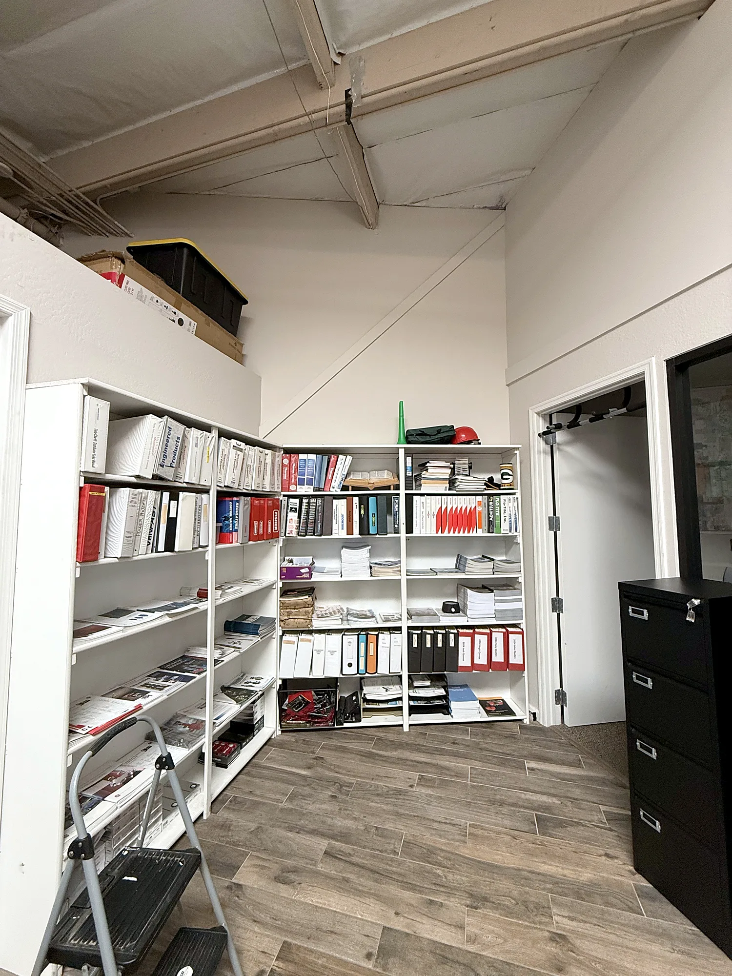 Before photo of the cluttered office with freestanding bookshelves