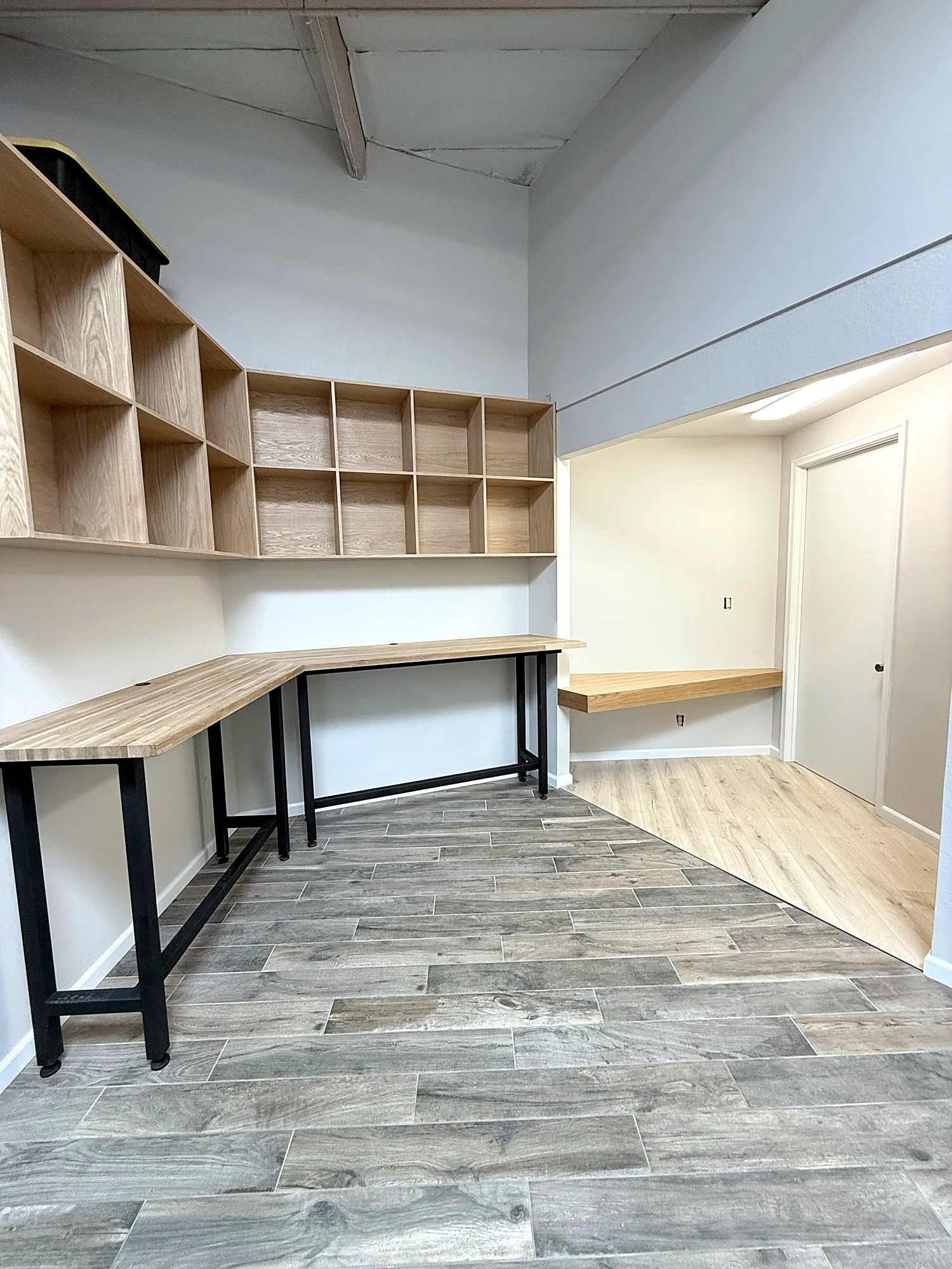 Finished office with custom white oak cubbies, L-shaped work bar and floating desk alcove
