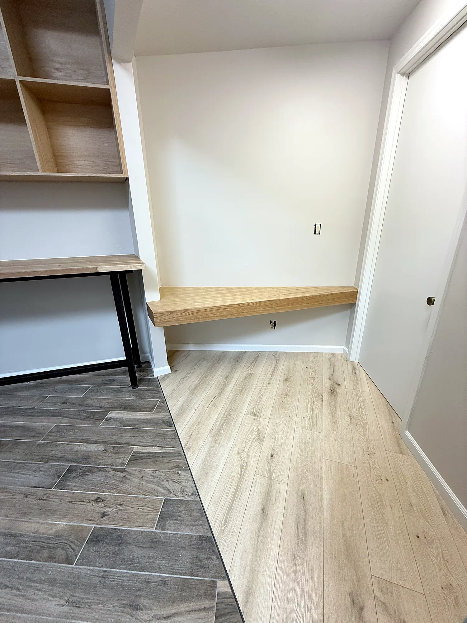 Floating white oak desk alcove with new oak laminate flooring meeting existing tile