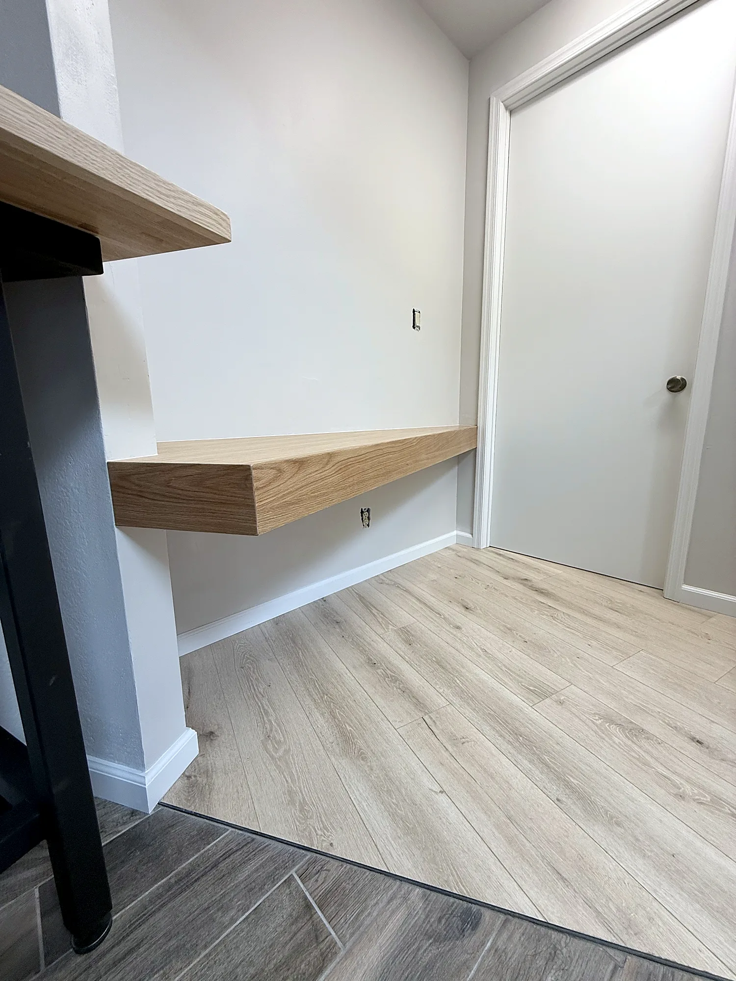 Side view of the floating desk with mitered white oak edges and new laminate flooring